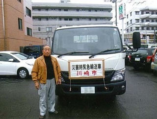 軽トラックの前に立つ松井さんの写真