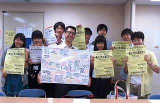 活動報告会のチラシ等を持つ学生たちの写真