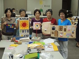 制作した絵本やおもちゃを手に持つ女性たちの写真