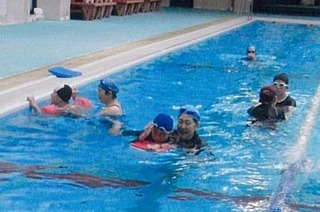 障がいのある子どもたちに水泳を教える母親たちの様子