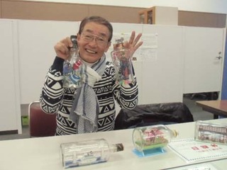 ボトル作品を手に持つ木村さんの写真